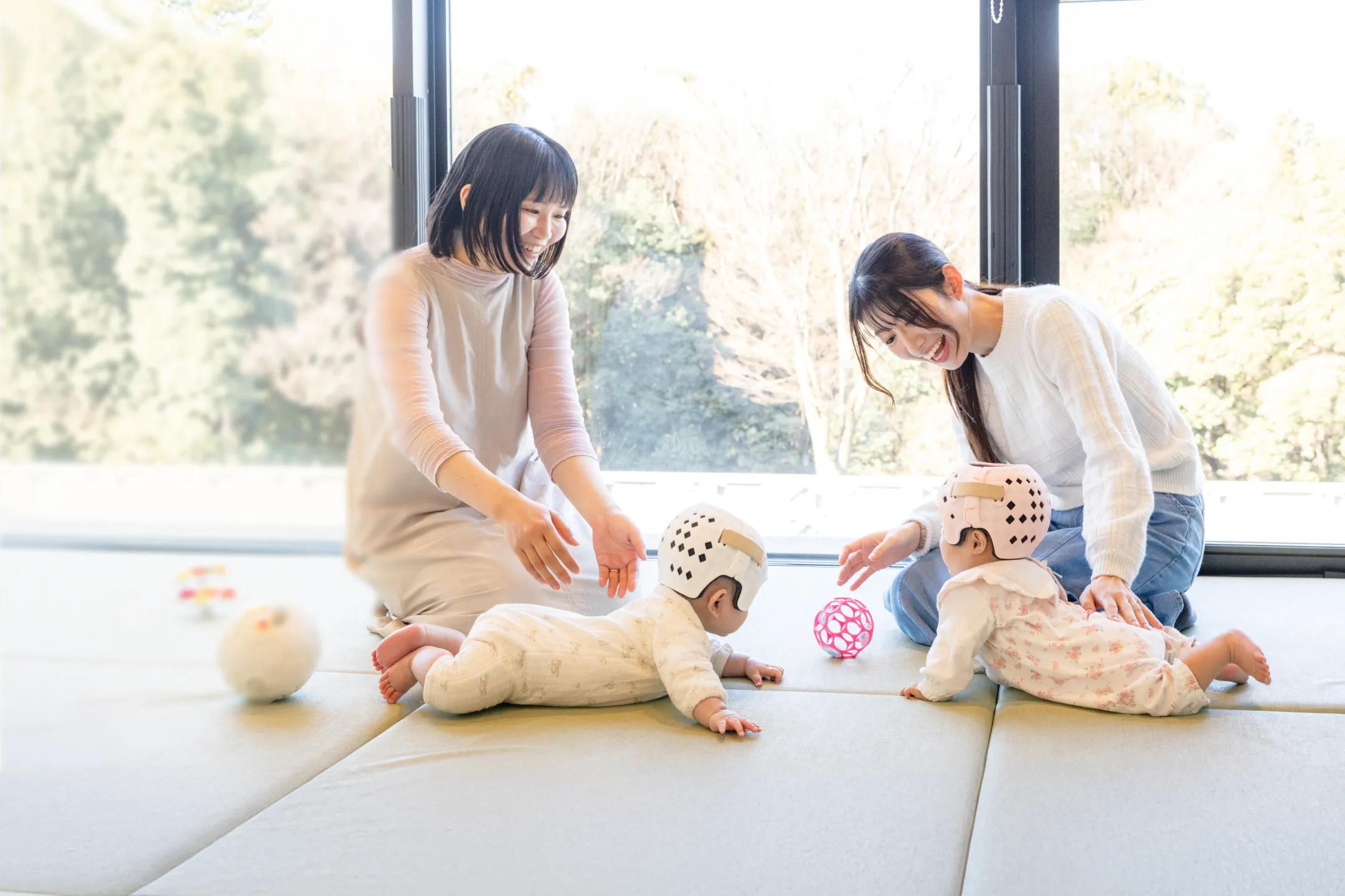 赤ちゃんと来院したご家族を迎える受付スタッフ
