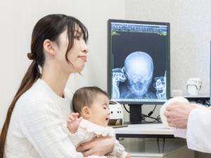 お母さんと子供がレントゲン画像を見ている写真